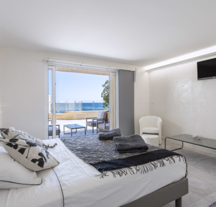 Maui room: a 160 cm double bed, TV, wardrobe and en-suite bathroom with Italian shower and island bath, vanity unit and separate toilet. room with Italian shower and island bath, washbasin and separate toilet. Small living room outside with sea view.