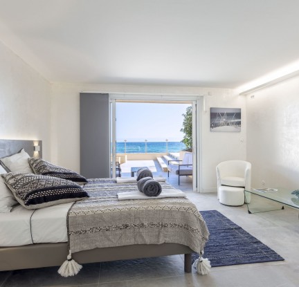 Chambre Aruba : un Lit double 160 cm, TV, penderie et salle de bain attenante avec douche à l’italienne et baignoire balnéo, meuble vasque et toilettes séparées. Petit salon extérieur vue mer.