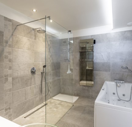 Chambre Aruba : un Lit double 160 cm, TV, penderie et salle de bain attenante avec douche à l’italienne et baignoire balnéo, meuble vasque et toilettes séparées. Petit salon extérieur vue mer.