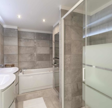 Chambre Dalupiri : un Lit double 160cm, TV, penderie et salle de bain avec douche et baignoire balnéo, meuble double vasque et toilettes. Terrasse avec store banne et petit salon extérieur vue jardin.