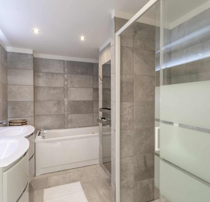 Chambre Dalupiri : un Lit double 160cm, TV, penderie et salle de bain avec douche et baignoire balnéo, meuble double vasque et toilettes. Terrasse avec store banne et petit salon extérieur vue jardin.