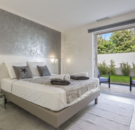 Chambre Maupiti : un Lit double 160 cm, TV, penderie et salle de bain avec douche à l’italienne et baignoire balnéo, meuble vasque et toilettes séparées. Petit salon extérieur vue jardin.