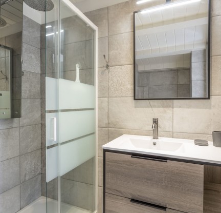 fr Chambre Santorini : un Lit double 140 cm, TV, penderie et salle d’eau avec douche, meuble vasque et toilettes.