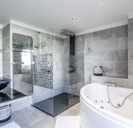 La chambre Tahaa : Lit double 160 cm, TV, penderie et salle de bain avec douche à l’italienne et baignoire balnéo, meuble vasque et toilettes séparées. Petit salon extérieur vue mer.