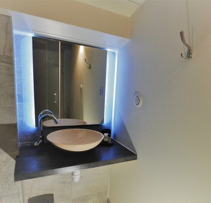 Chambre familiale avec un lit double 140 cm et deux lits simples. Salle d’eau avec douche, meuble vasque et toilettes.